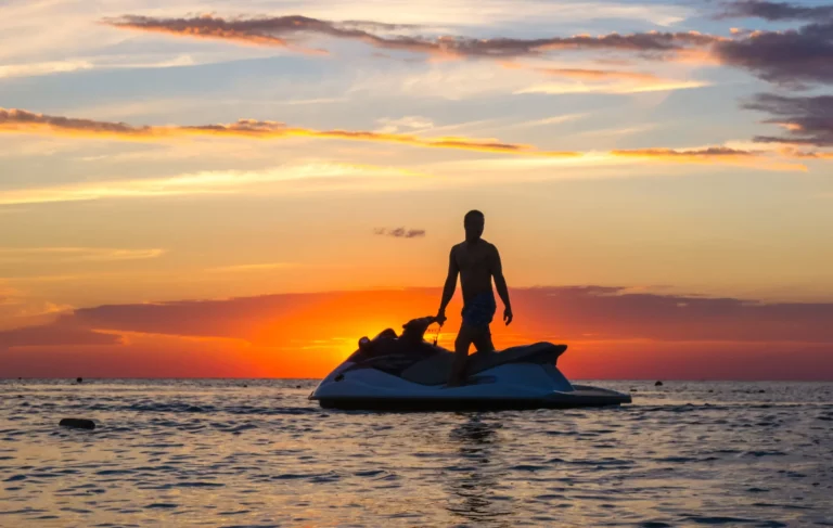 silueta de un hombre en una moto acuática al sol